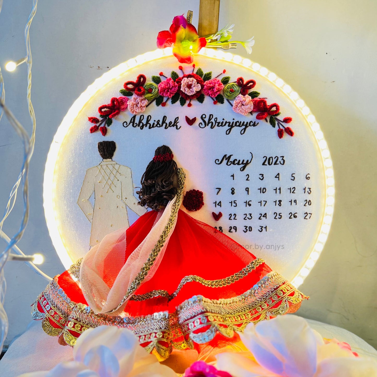 Decorative calendar with floral design and couple illustration, featuring the month of May 2023.