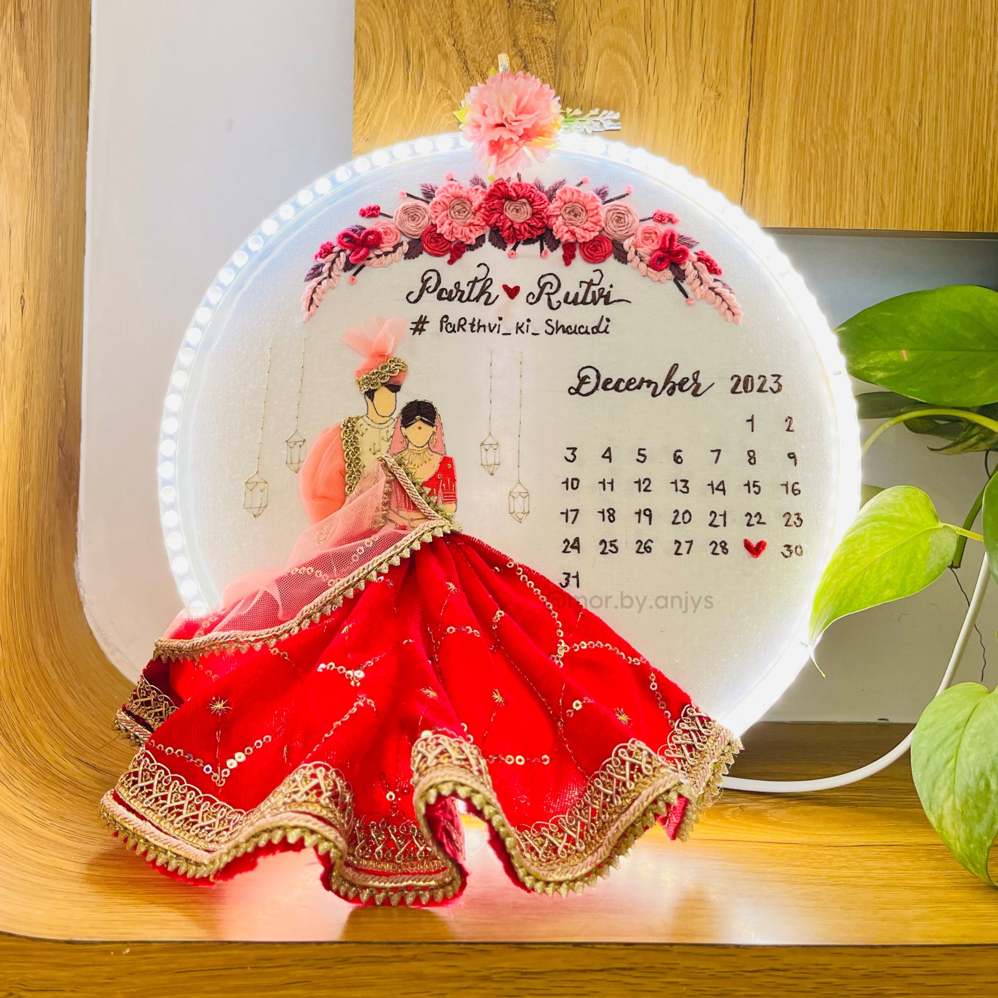 Decorative calendar with a couple in traditional attire on a wooden surface.