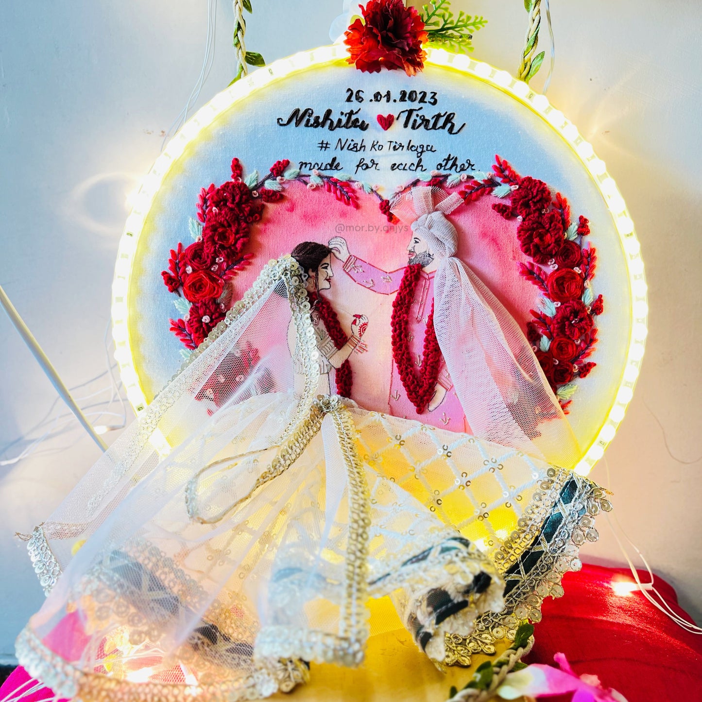 Decorative wall art with a couple in wedding attire and floral elements.