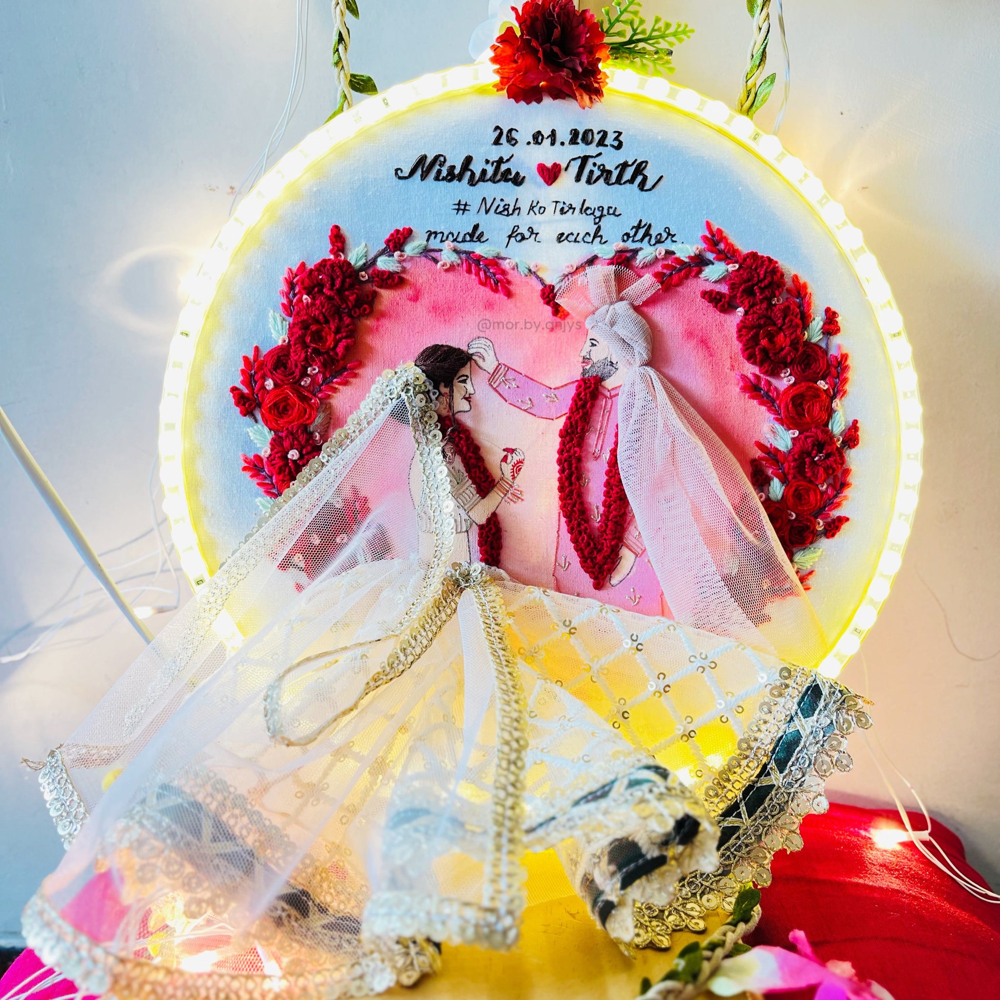 Decorative wall art with a couple in wedding attire and floral elements.