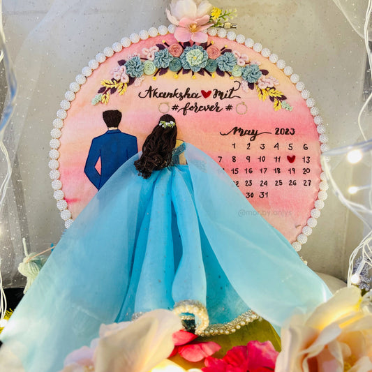 Decorative calendar with a couple in formal attire and floral elements, featuring the text 'Aakansha & Mit forever'.