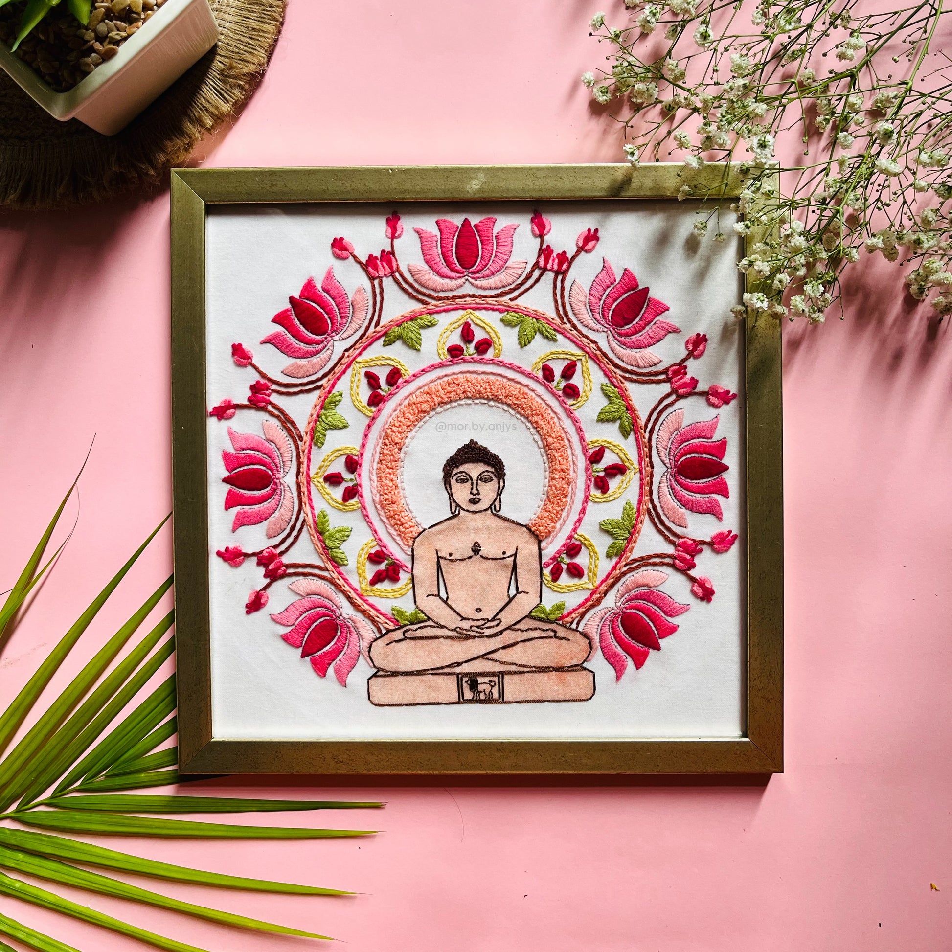 Framed artwork of a meditating figure surrounded by pink lotus flowers on a pink background.