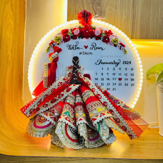 Decorative calendar with a colorful dress and LED lights on a wooden surface