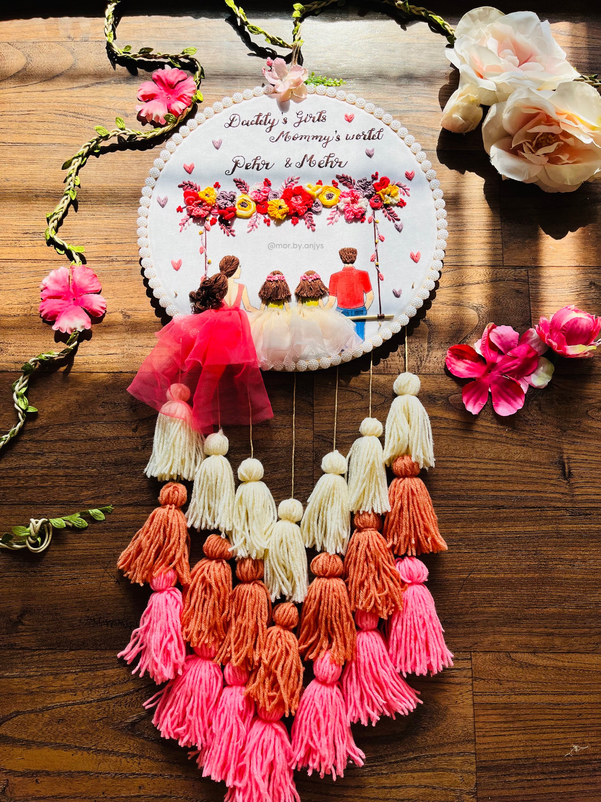 Decorative wall hanging with tassels and floral elements on a wooden surface
