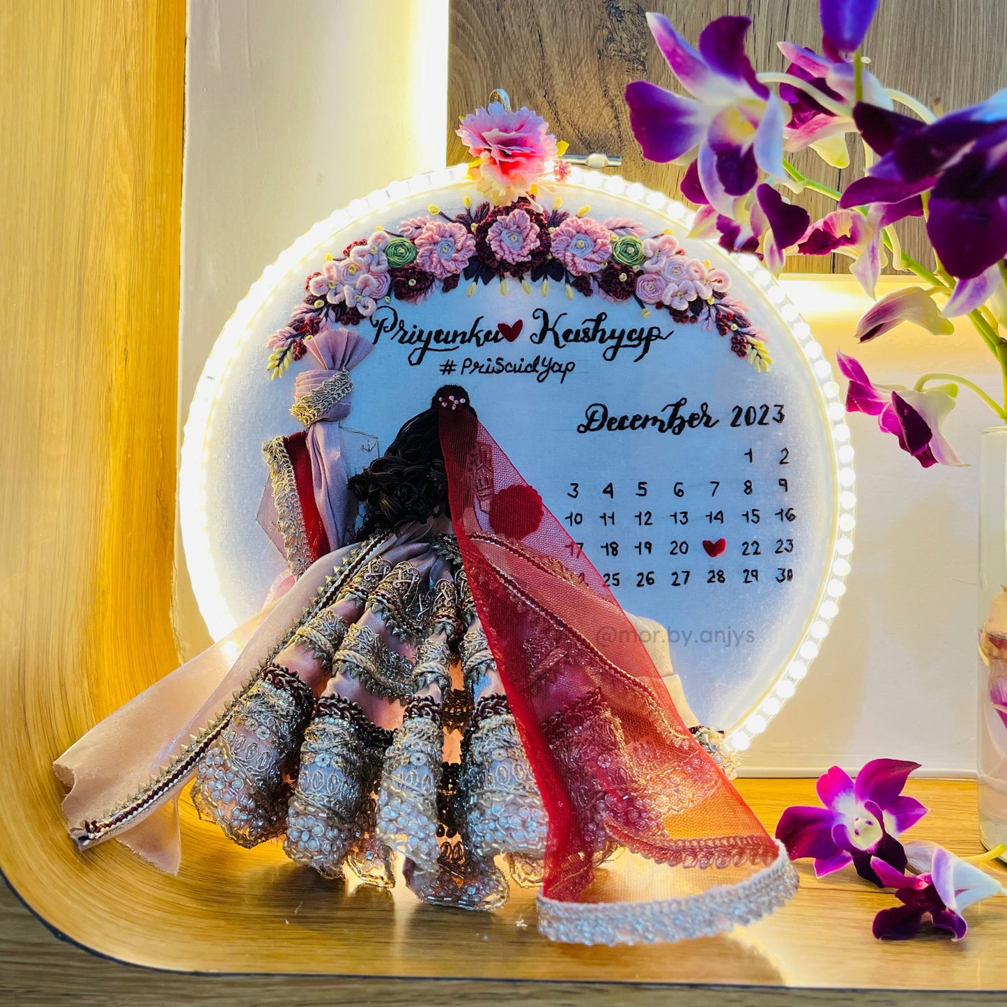 Decorative calendar with floral design and a woman's silhouette on a wooden surface.