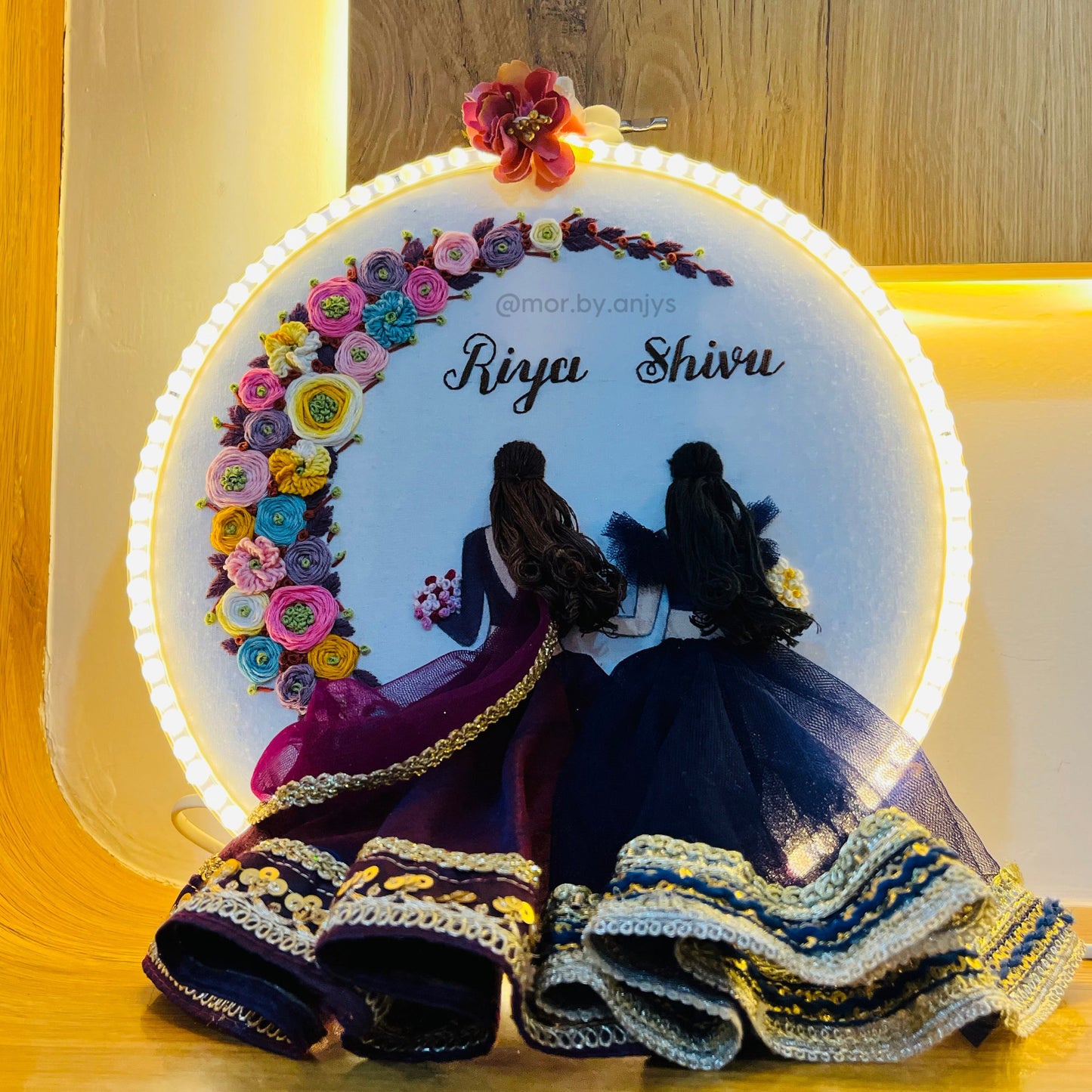 Decorative plate with floral design and two silhouettes on a wooden surface