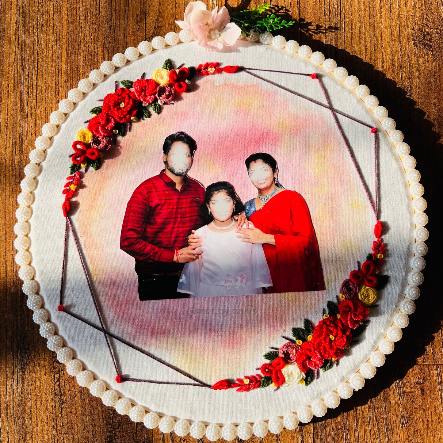 Decorative cake with a family photo and floral decorations on a wooden surface