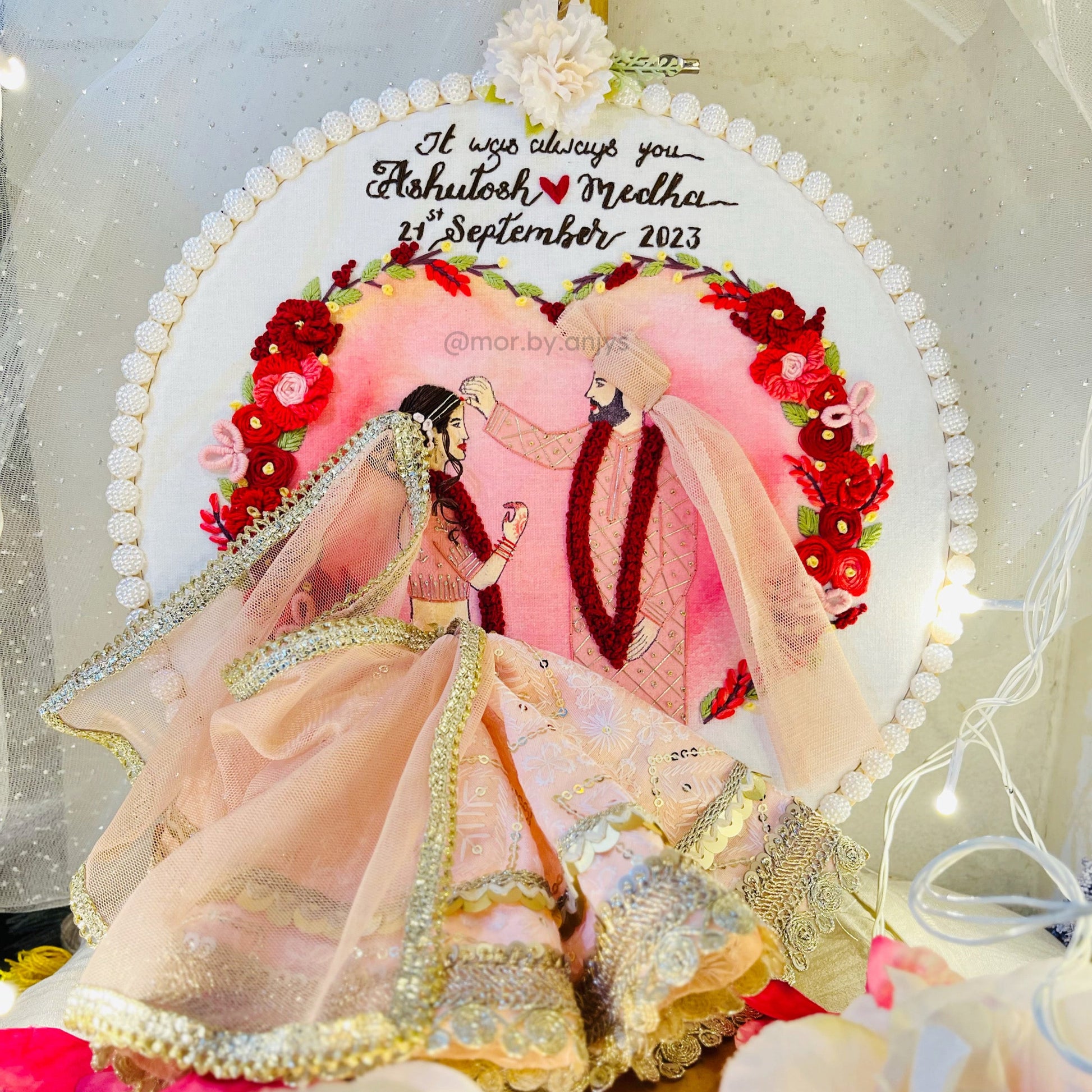 Decorative cake with a couple in traditional attire and floral design, featuring personalized text.