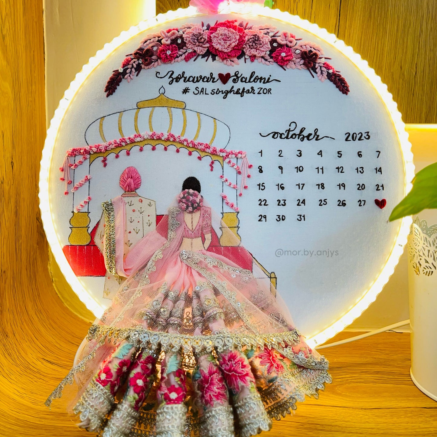 Decorative calendar with floral design and couple illustration on a wooden surface